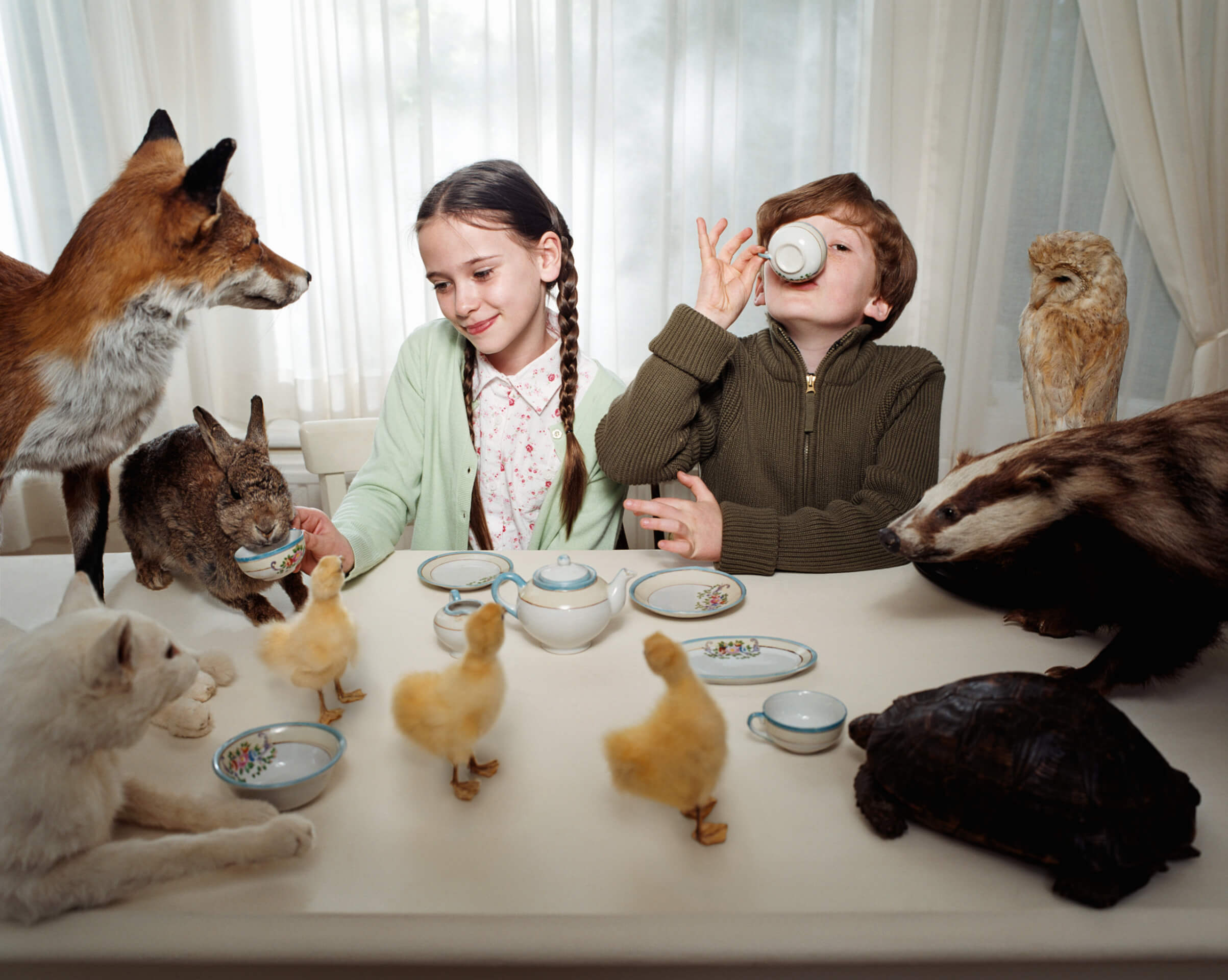 Children having a tea party with animals